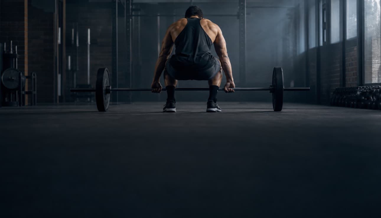 A lifter setting up a barbell deadlift
